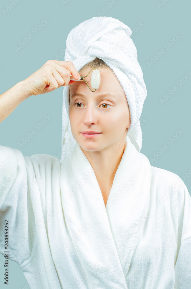 Face massage. Beautiful woman getting massage face using roller massager Face massage. Beautiful woman getting massage face using roller massager