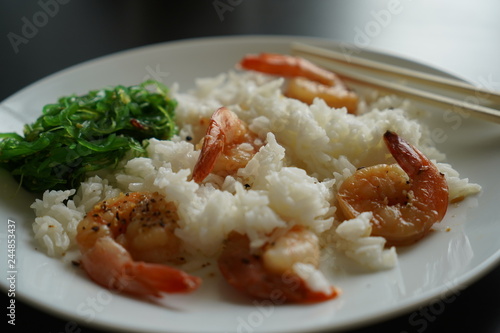 rice with shrimps on a white plate close-up