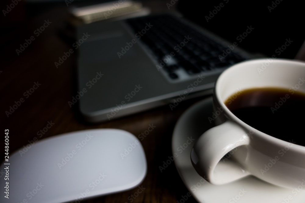 Close up office desk table with laptop, note book, mobile coffee and pen. Selective focus. Business concept. Copy space.