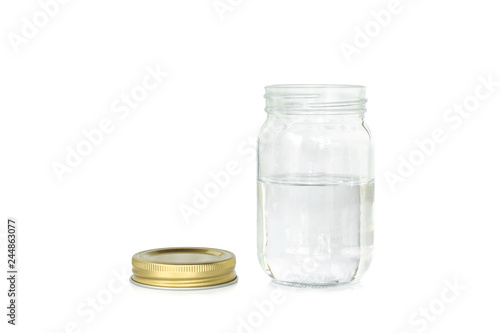 Water into jar of golden cap is open on a white background.