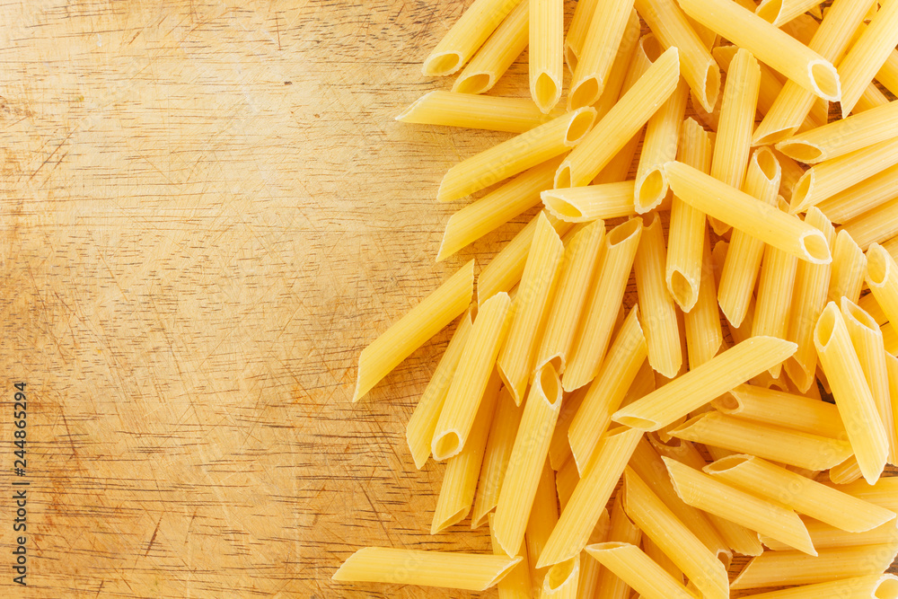dry pasta penne Italian food wooden background. dry pasta penne Italian food wooden background.