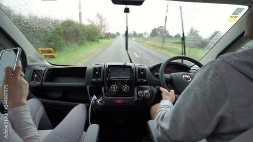 View from inside of a van - couple driving in a rainy weather in New Zealand photo