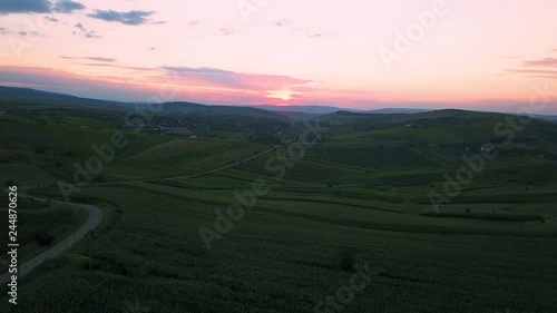 Aerial footage. Drone rising above large corn field and other farm fields right before sunset photo