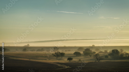 Spring foggy dawn in the steppe. Panorama of a wide valley.