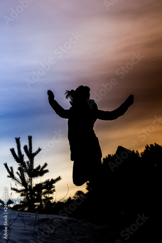 silhouette of a girl jumping in winter