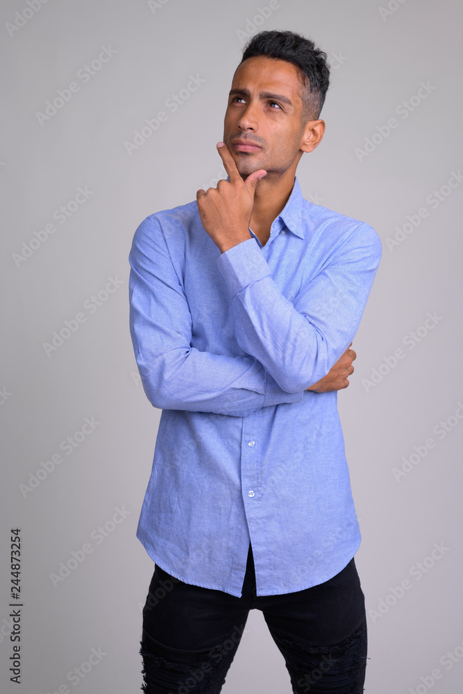 Portrait of young handsome Persian businessman thinking Portrait of young handsome Persian businessman thinking