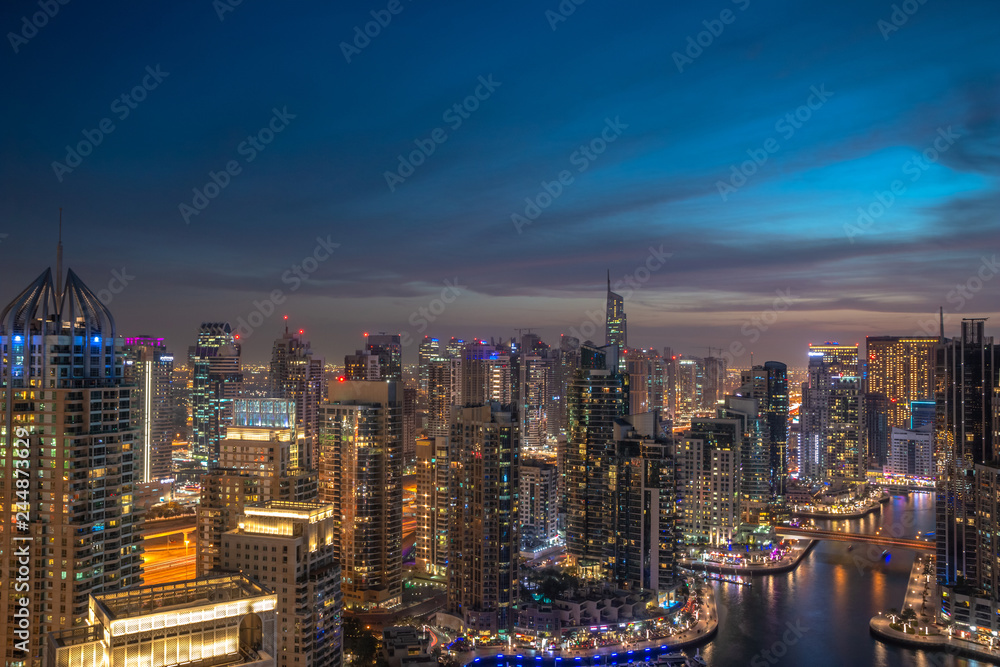 Panoramic view over famous Dubai Marina skyline. Colorful background with modern skyscrapers and glittering night lights