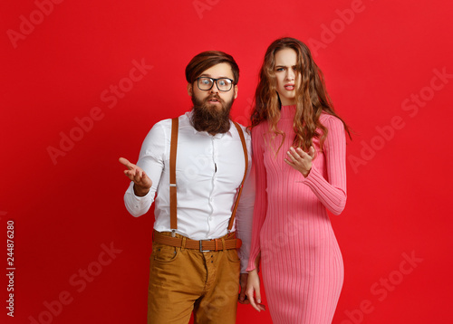 couple of emotional people man and woman on red background.