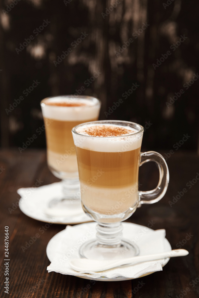 Cappuccino with cinnamon. Cup of coffee on wooden background Cappuccino with cinnamon. Cup of coffee on wooden background