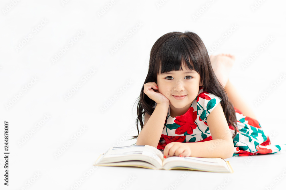 smiling little girl with book lying on the floor smiling little girl with book lying on the floor