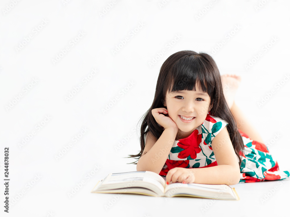 smiling little girl with book lying on the floor smiling little girl with book lying on the floor