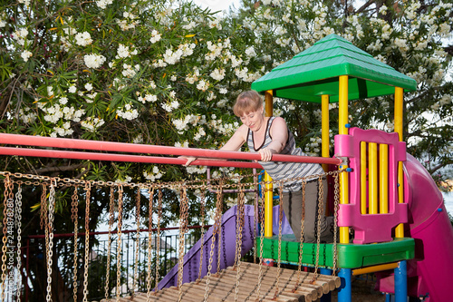 Middle-aged woman on the Playground outdoors in a summer