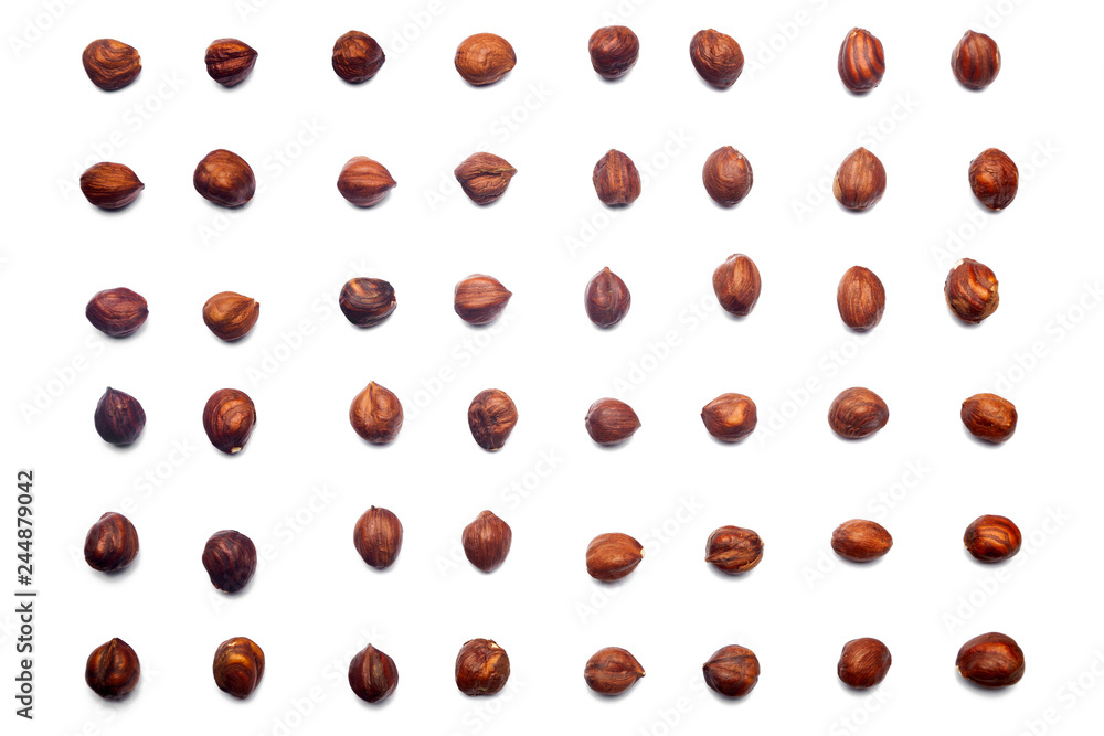 A collection of hazelnuts lie in straight rows along dioganals on an isolated white background. with clipping path. Hazelnuts pattern A collection of hazelnuts lie in straight rows along dioganals on an isolated white background. with clipping path. Hazelnuts pattern