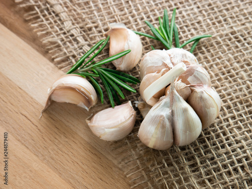 Fresh garlic with rosemary,  rustic style, wooden background