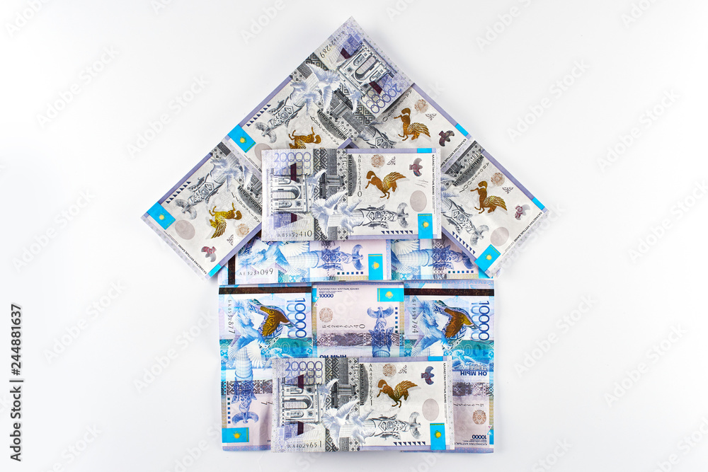 Fototapeta premium Tenge. Kazakh money in the shape of a house on a white background. Real estate loan concept.