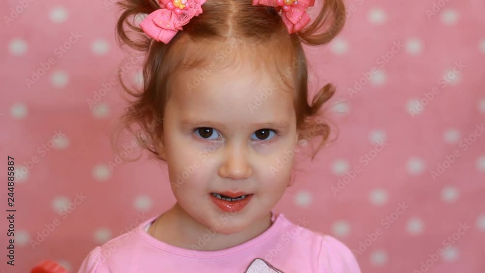 Child girl smiling and eating sweet candy lollipop. Baby closeup portrait Child girl smiling and eating sweet candy lollipop. Baby closeup portrait