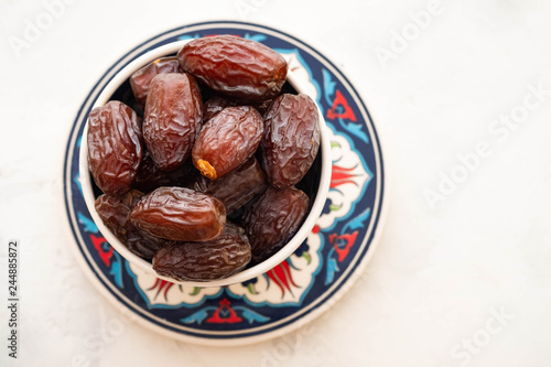 Fresh Medjool Dates in a bowl. Ramadan kareem. White background. Turkish style. Top view. Copy space.