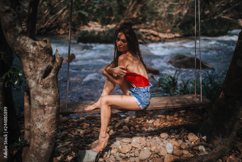 girl at the mountain river on a swing