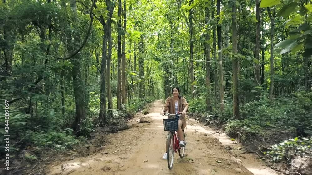 Beautiful Asian girl enjoy travel in forest at countryside of Thailand by riding on bicycle Beautiful Asian girl enjoy travel in forest at countryside of Thailand by riding on bicycle