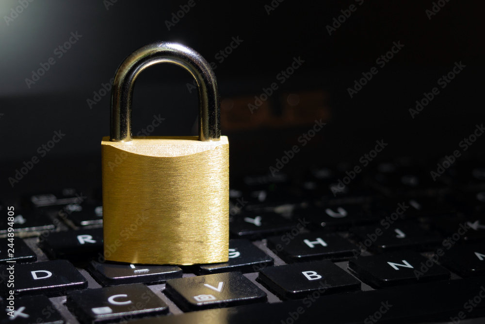 cyber safety concept, lock in spotlight on laptop computer keyboard cyber safety concept, lock in spotlight on laptop computer keyboard