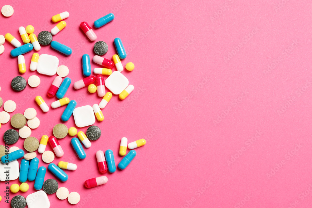 Multi-colored vitamins on a pink background. Place for text. Top view. Multi-colored vitamins on a pink background. Place for text. Top view.