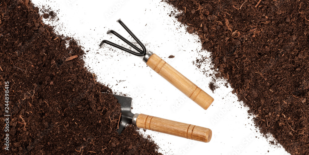 Garden tools in soil isolated on white background . Top view Garden tools in soil isolated on white background . Top view