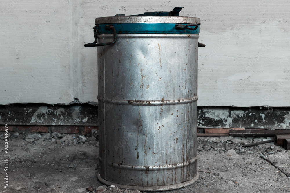 Old metal barrel with an unknown substance inside. Barrel with blue border