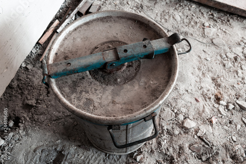 The top cover of an old metal barrel with an unknown substance inside. Barrel with blue border