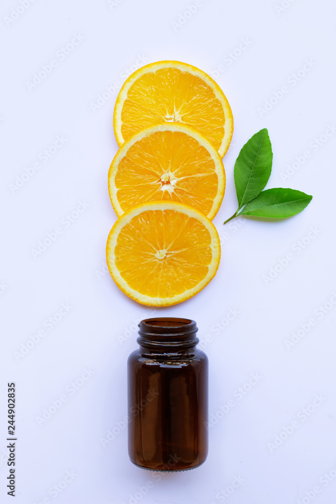 Brown medicine glass bottle with orange fruit slices and green leaves on white Brown medicine glass bottle with orange fruit slices and green leaves on white
