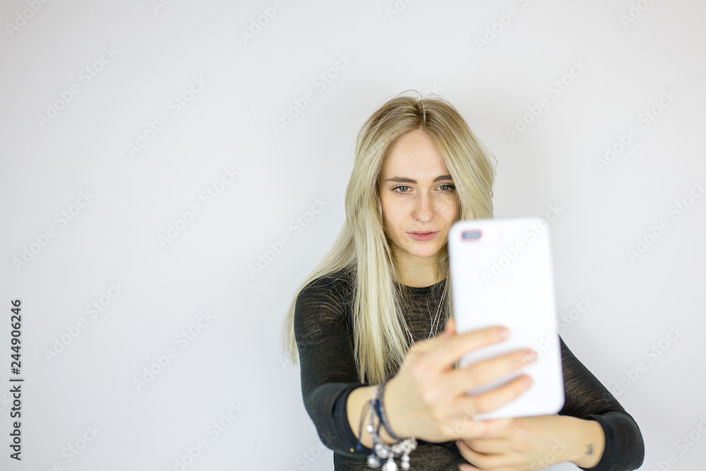Naklejka premium Modern blonde takes a selfie on the phone