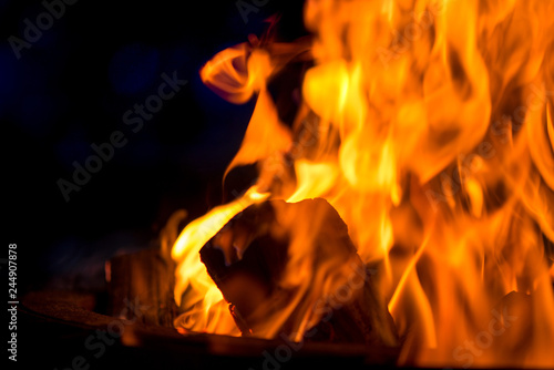 Ignite the fire. Warming up the cold winter nights. A macro shot of firewood, white dust and hot, glowing coal. Burning branches and wood. Flames in the fireplace, cozy home, warmth, love, romantic 