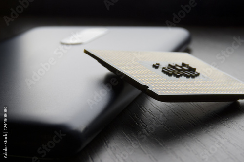 phone and processor chip lie on wooden table