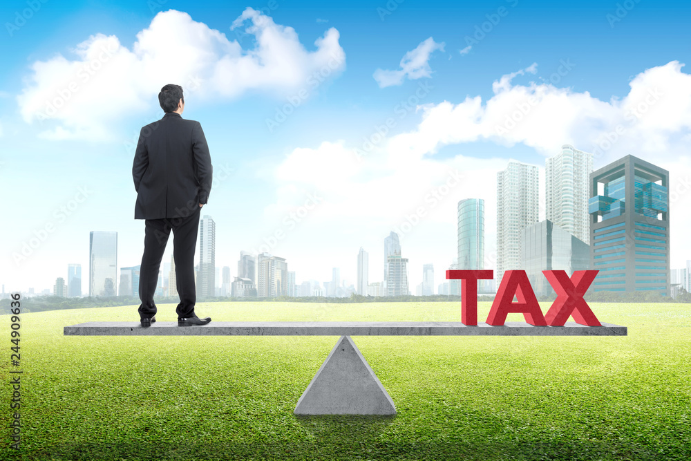 Rear view of asian businessman standing balance with tax Rear view of asian businessman standing balance with tax