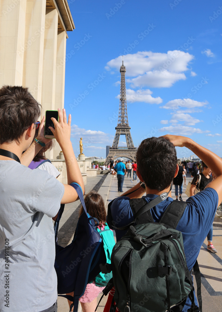 young tourists photograph the Eiffel Tower