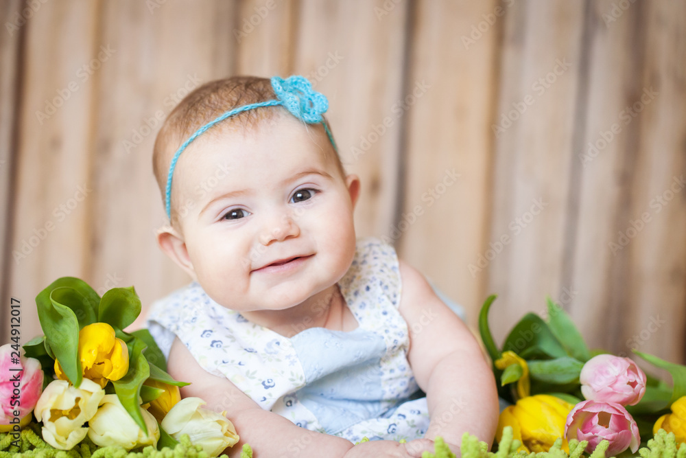 Fototapeta Adorable baby girl with tulips
