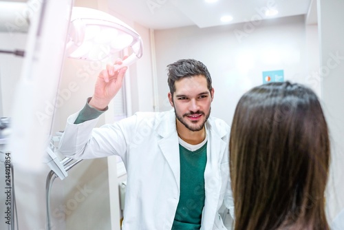 Male dentist adjust searchlight before starting work