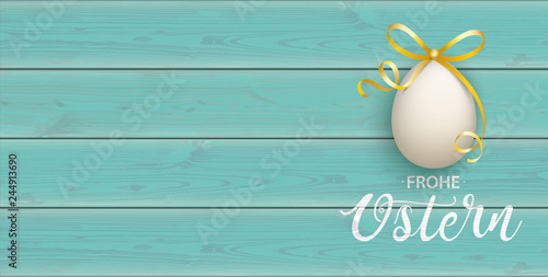 Frohe Ostern Banner mit Osterei auf türkisfarbenen Holzbrettern