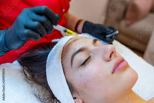 Needle mesotherapy in beauty clinic. Cosmetics injected to woman's face. photo