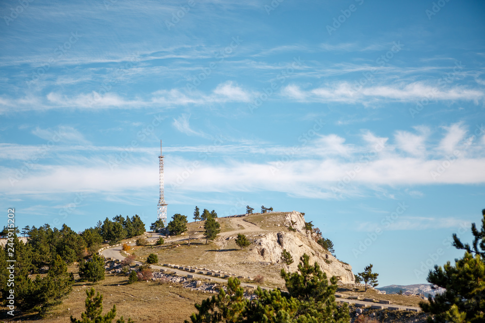Photo of mountainous area, road, tower, blue sky