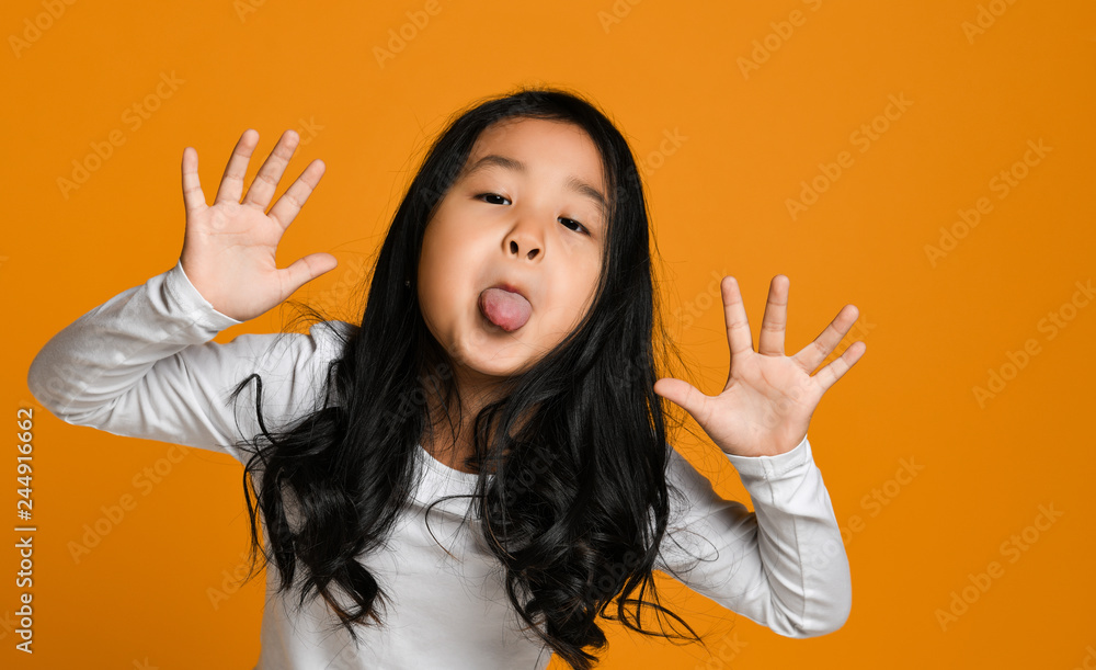 funny cute little asian girl shows the tongue Stock Photo | Adobe Stock