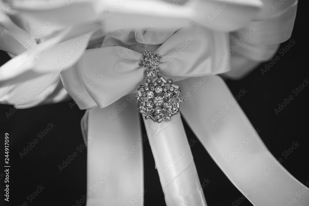 bouquet details showing white ribbon and jewellery at a wedding bouquet details showing white ribbon and jewellery at a wedding