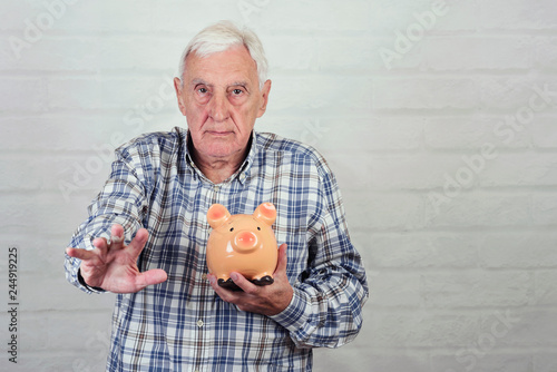Obraz na płótnie senior man with a piggybank