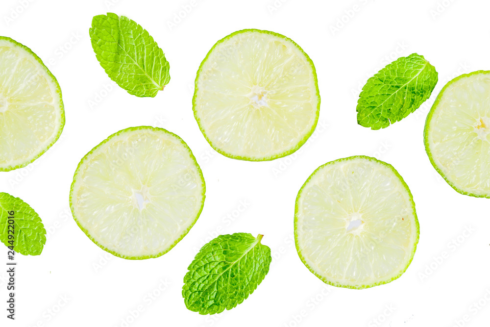 Fresh lime slice with mint leaves isolated on white background, top view copy space. Summer refreshment cocktail ingredient concept.
