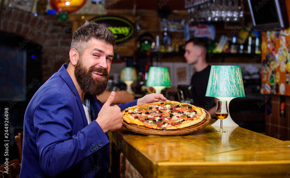 Hipster hungry eat italian pizza. Hipster client sit at bar counter. Man received delicious pizza. Enjoy your meal. Cheat meal concept. Pizza favorite restaurant food. Fresh hot pizza for dinner