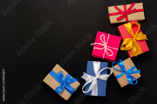 A lot of gift boxes on a black background. Holiday concept, New Year, Christmas, Birthday, Valentine's Day. Copy space. Flat lay, top view.