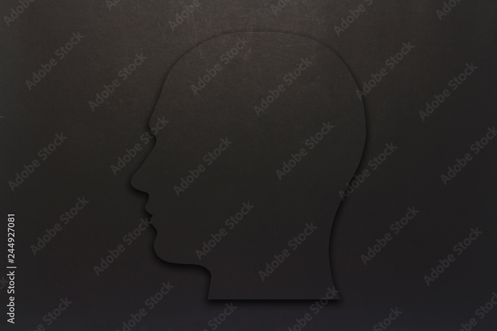 Black cardboard head on a black background. Copy space. Flat lay, top view.