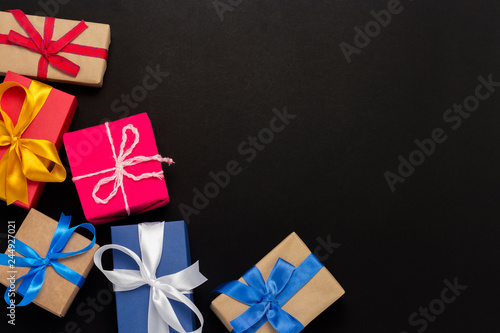 A lot of gift boxes on a black background. Holiday concept, New Year, Christmas, Birthday, Valentine's Day. Copy space. Flat lay, top view.