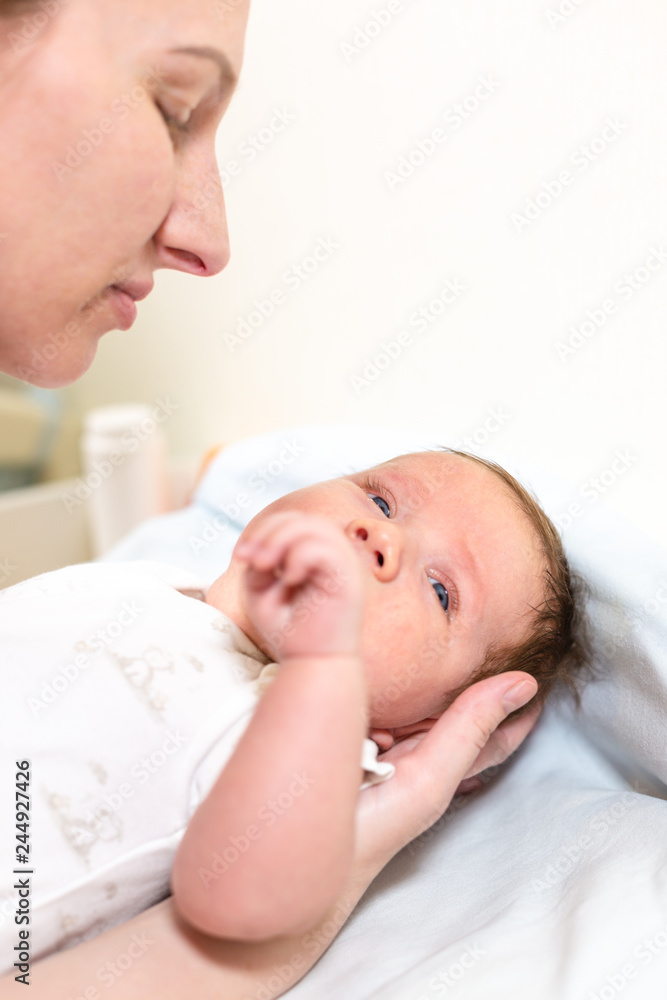 Young mother hugging her newborn child. Mom nursing baby. Family at home. Love, trust and tenderness concept. Young mother hugging her newborn child. Mom nursing baby. Family at home. Love, trust and tenderness concept.