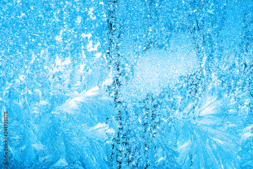 Abstract winter background - blue frozen window outdoors