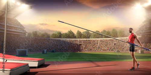 Young male pole vault athlete with pole bar. Men in sport clothes at athletic sport track in professional stadium